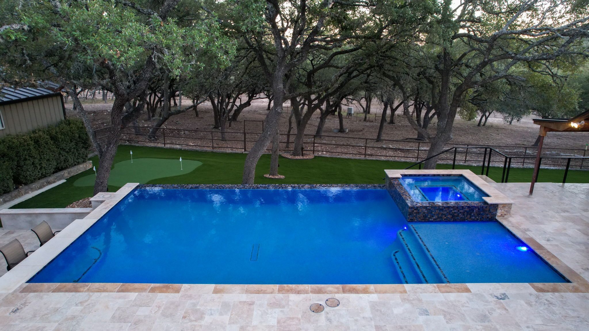 Drone view of custom pool with landscaping