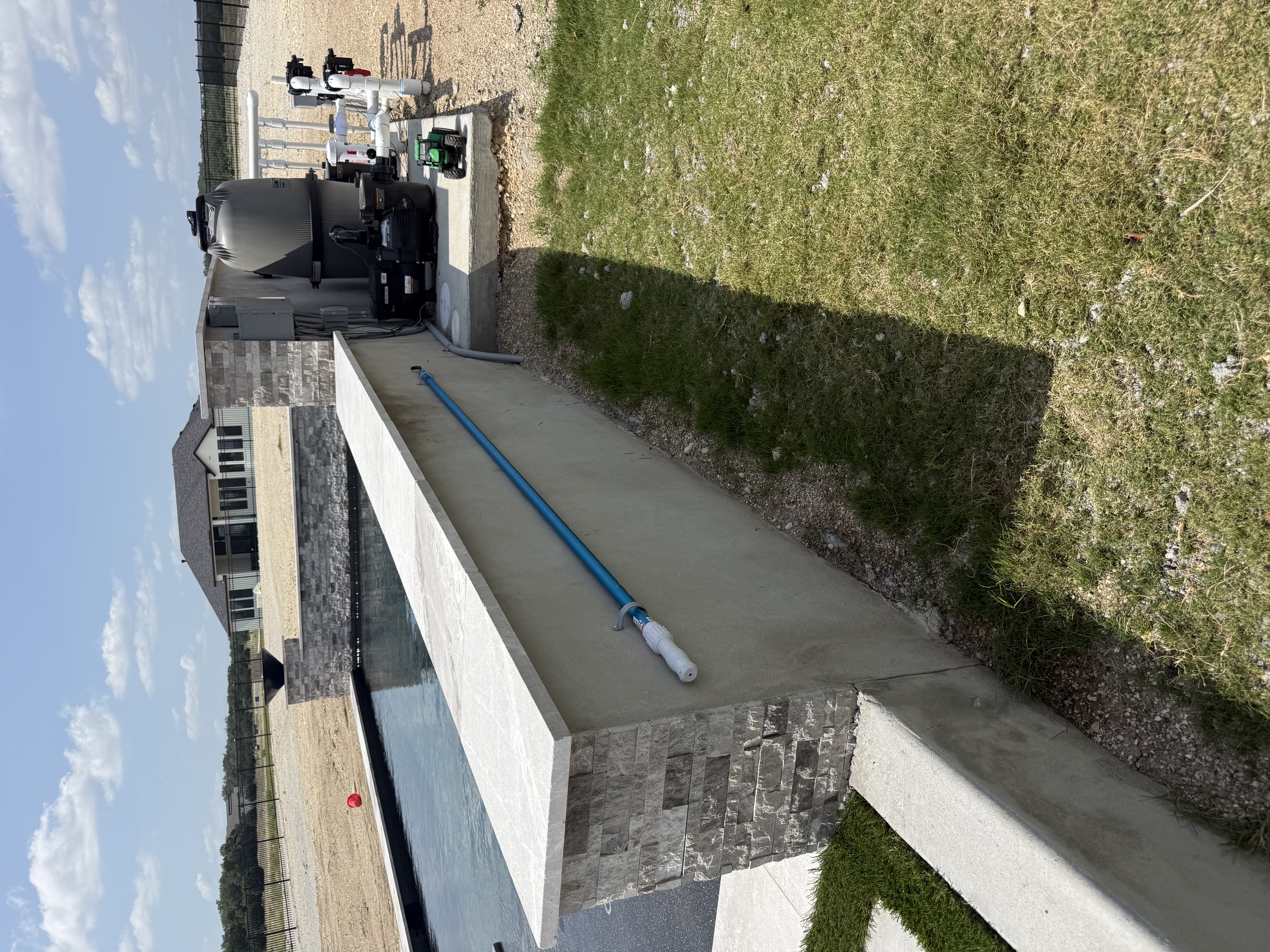 Boerne pool equipment pad with filter, pump and PVC plumbing beside a stone-capped concrete wall