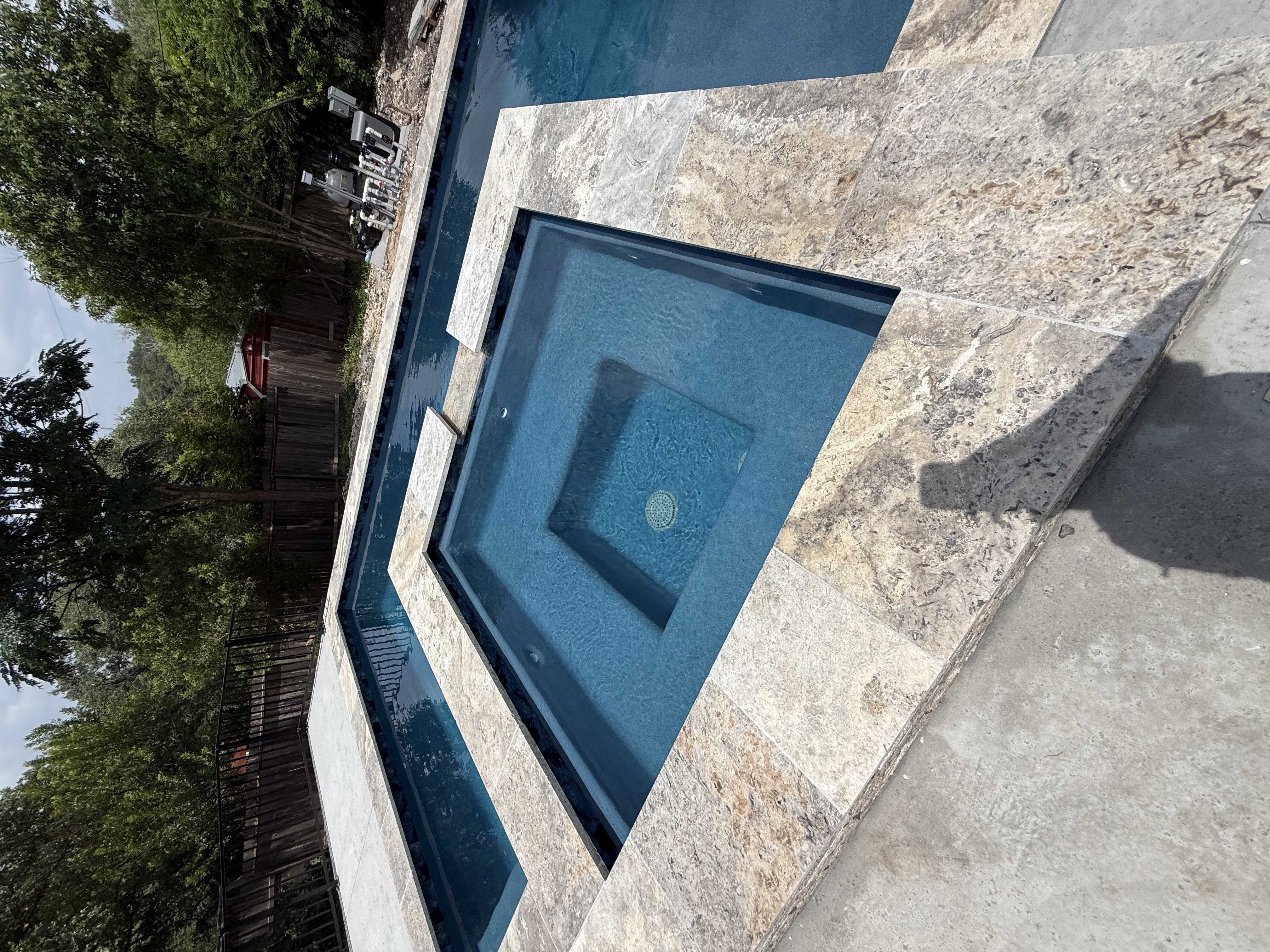 San Antonio square-in-square pool and spa edged with natural stone tiles and a concrete patio
