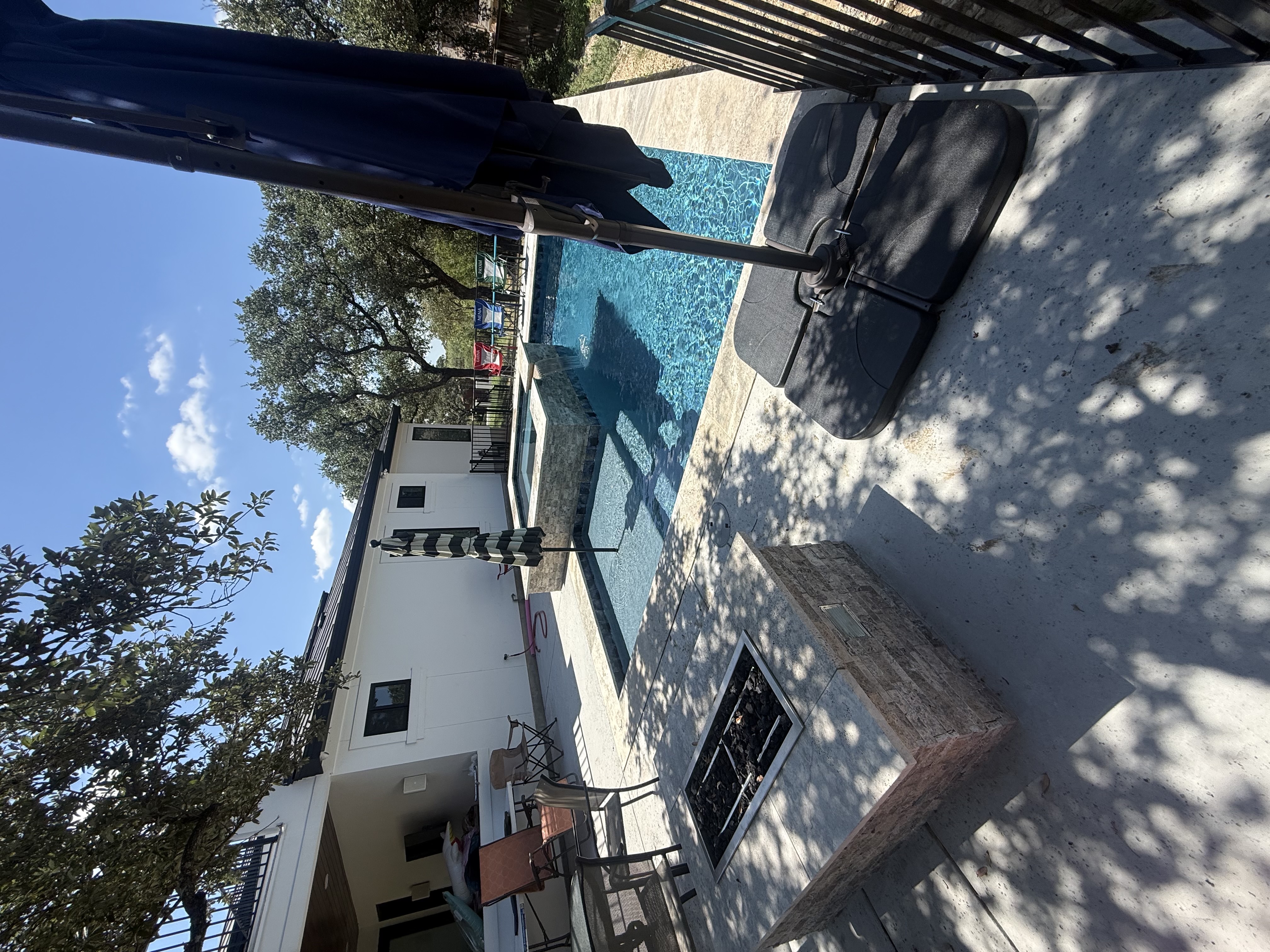 San Antonio pool with a stone-encased spa and a square fire pit built into the patio floor